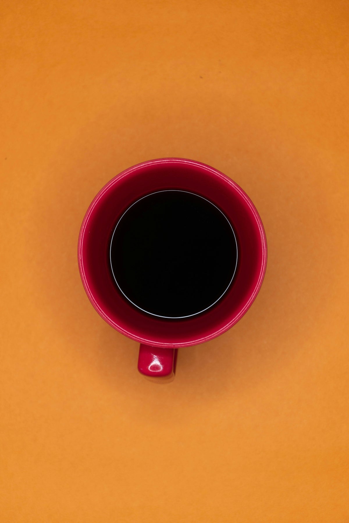 black liquid in pink ceramic mug