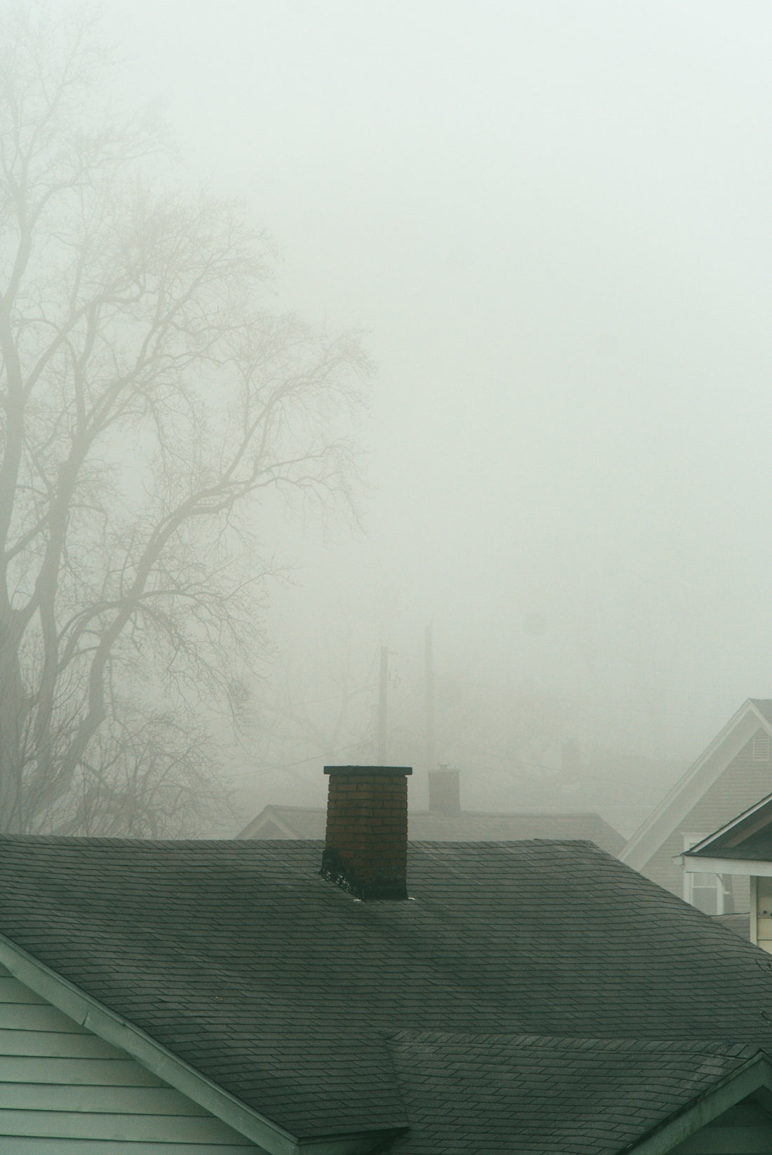 a house with a clock tower in the fog