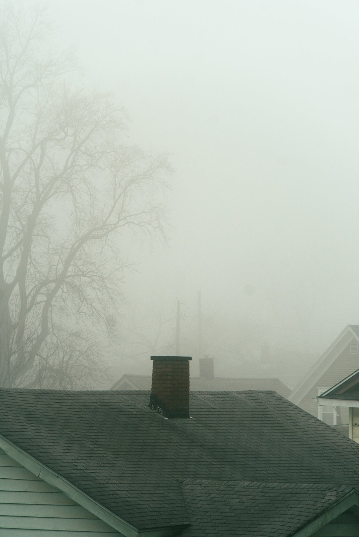 a house with a clock tower in the fog